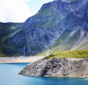 Scenic view of sea and mountains against sky