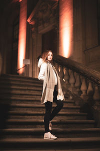 Full length of woman standing on staircase