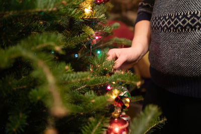 Midsection of woman with christmas tree