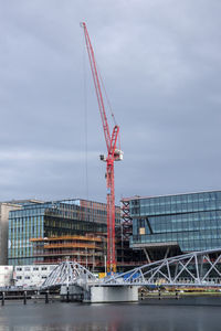 Cranes at construction site against sky