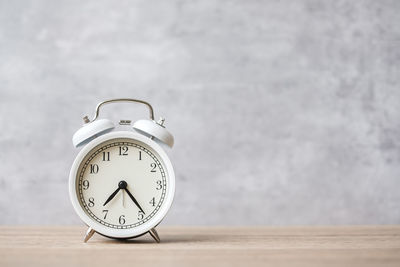 Close-up of clock on table against wall