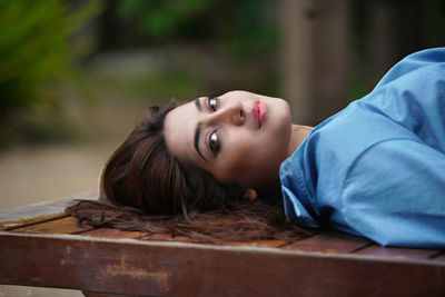 High angle view of young woman sitting on wood