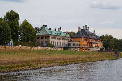 Building by river against sky