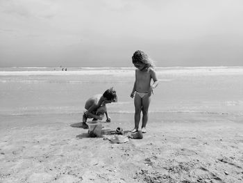 Full length of friends on beach against sea