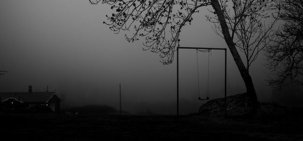 Silhouette tree on field against sky at dusk