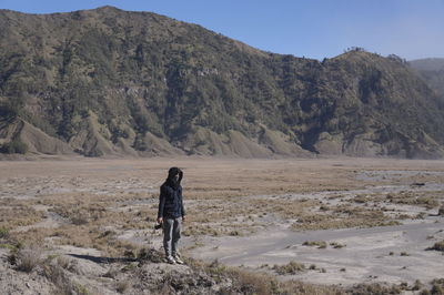 Rear view of man walking on mountain road