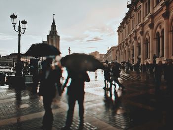 People walking on wet street in city