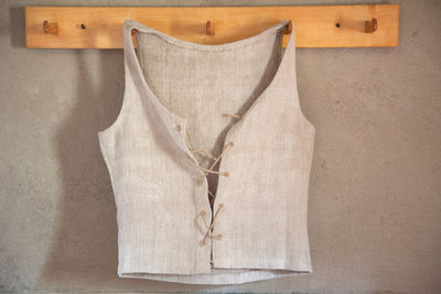 Close-up of waistcoat hanging on wooden hook