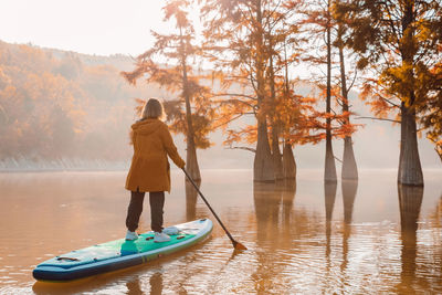 Rear view of woman standing in lake