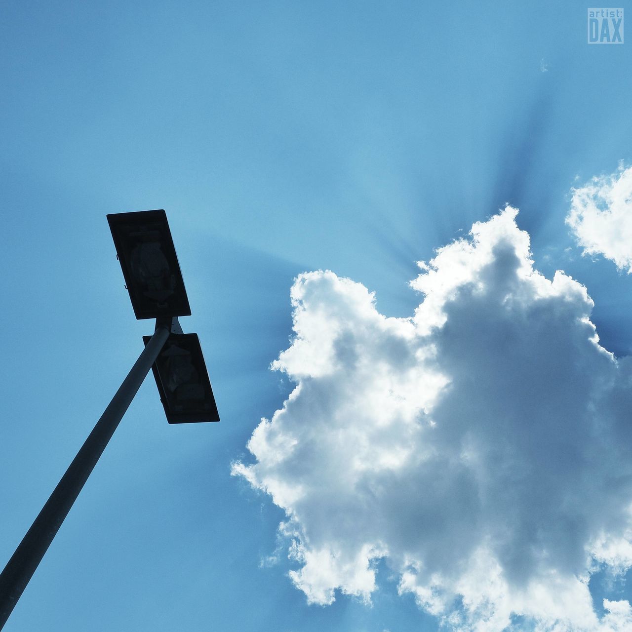 low angle view, sky, blue, cloud - sky, street light, lighting equipment, cloud, nature, outdoors, no people, day, pole, silhouette, copy space, beauty in nature, guidance, tranquility, cloudy, high section, sunlight