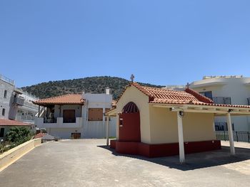 Houses in town against clear blue sky