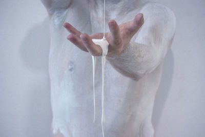 Midsection of woman standing against white background