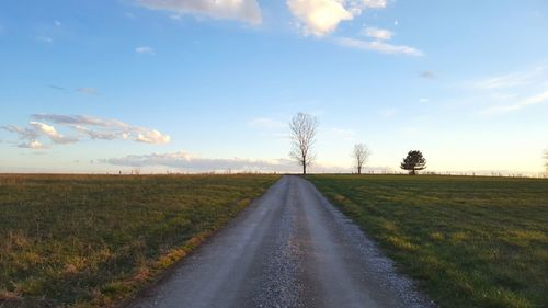 Surface level of country road against cloudy sky