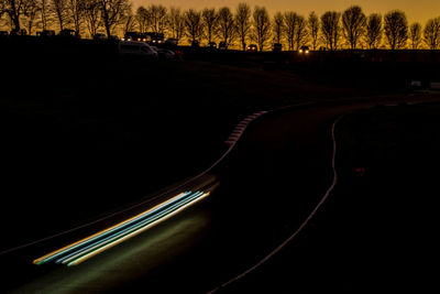 Silhouette of car on road at night