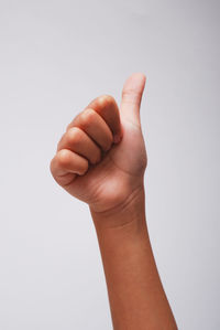 Close-up of hand sign against white background