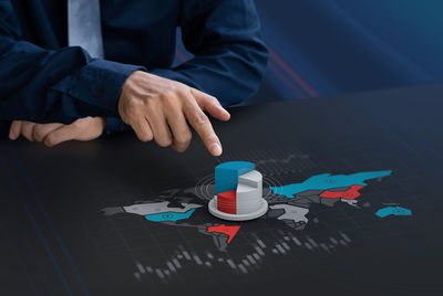 Midsection of person with umbrella on table