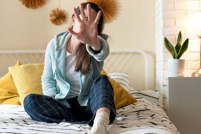 Portrait of young woman sitting on sofa at home