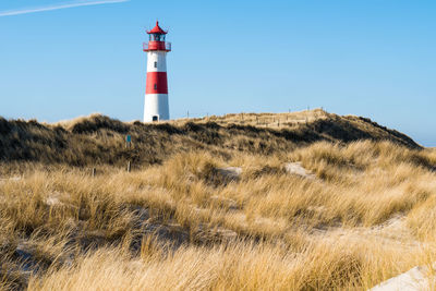 Lighthouse on field against clear sky