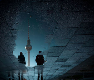 Low angle view of people on street against building at night