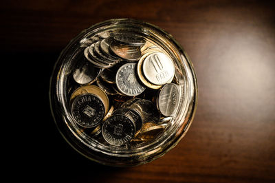 High angle view of coins in jar on table