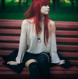 Beautiful young woman sitting in park