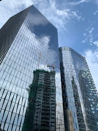 Low angle view of modern glass building against sky