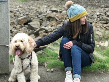 High angle view of mature woman with dog sitting on field