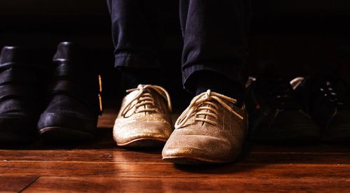 Low section of people with shoes on hardwood floor