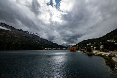 Scenic view of lake by mountains against sky