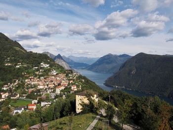 Scenic view of townscape by mountains against sky