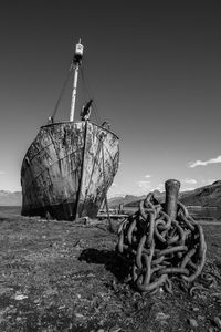 Abandoned boat at beach against sky