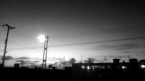 Low angle view of illuminated street lights against sky