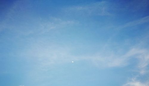 Low angle view of moon in blue sky