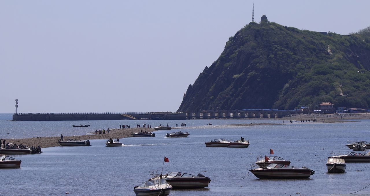 transportation, nautical vessel, water, mode of transport, sea, boat, built structure, architecture, waterfront, clear sky, building exterior, travel, copy space, incidental people, nature, travel destinations, river, mountain, day, moored