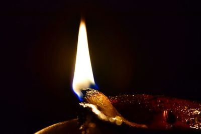 Close-up of lit candle in dark room