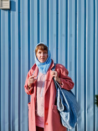 Portrait of woman standing against wall