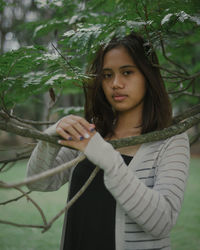 Portrait of beautiful woman standing against plants