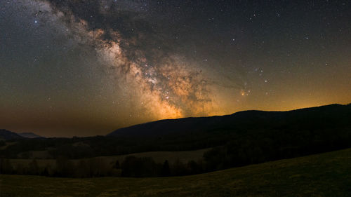 Scenic view of mountains against sky at night