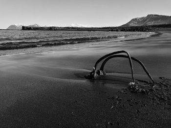 Tire tracks on beach against clear sky