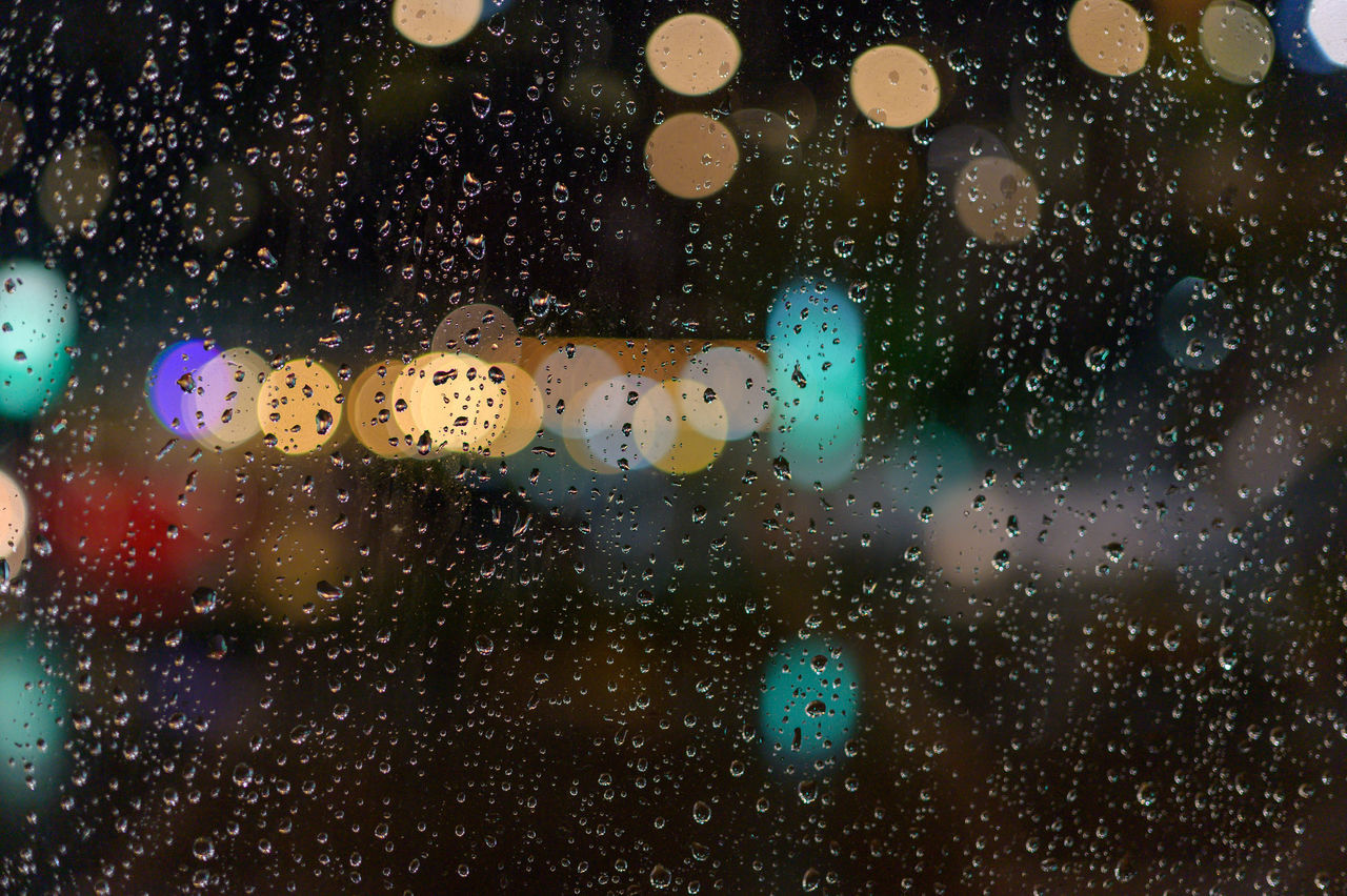 CLOSE-UP OF WET GLASS WINDOW IN RAINY SEASON