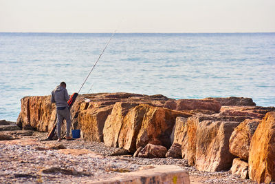 Young man on the beach preparing his fishing rod