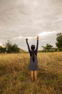 Rear view of woman standing on field