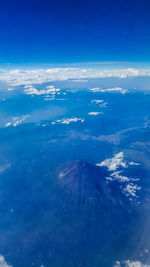 Aerial view of volcanic landscape against blue sky
