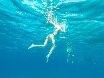 Low section of man swimming in pool