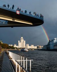 Bridge over river in city against sky