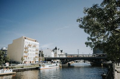 Bridge over river in city against sky