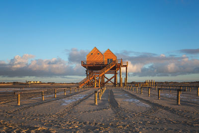 Lifeguard hut on beach against blue sky