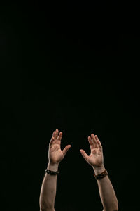 Midsection of person standing against black background