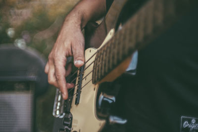 Midsection of man playing guitar