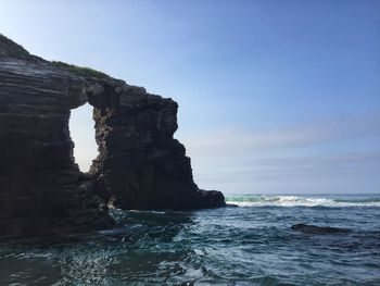 Rock formation on sea against sky